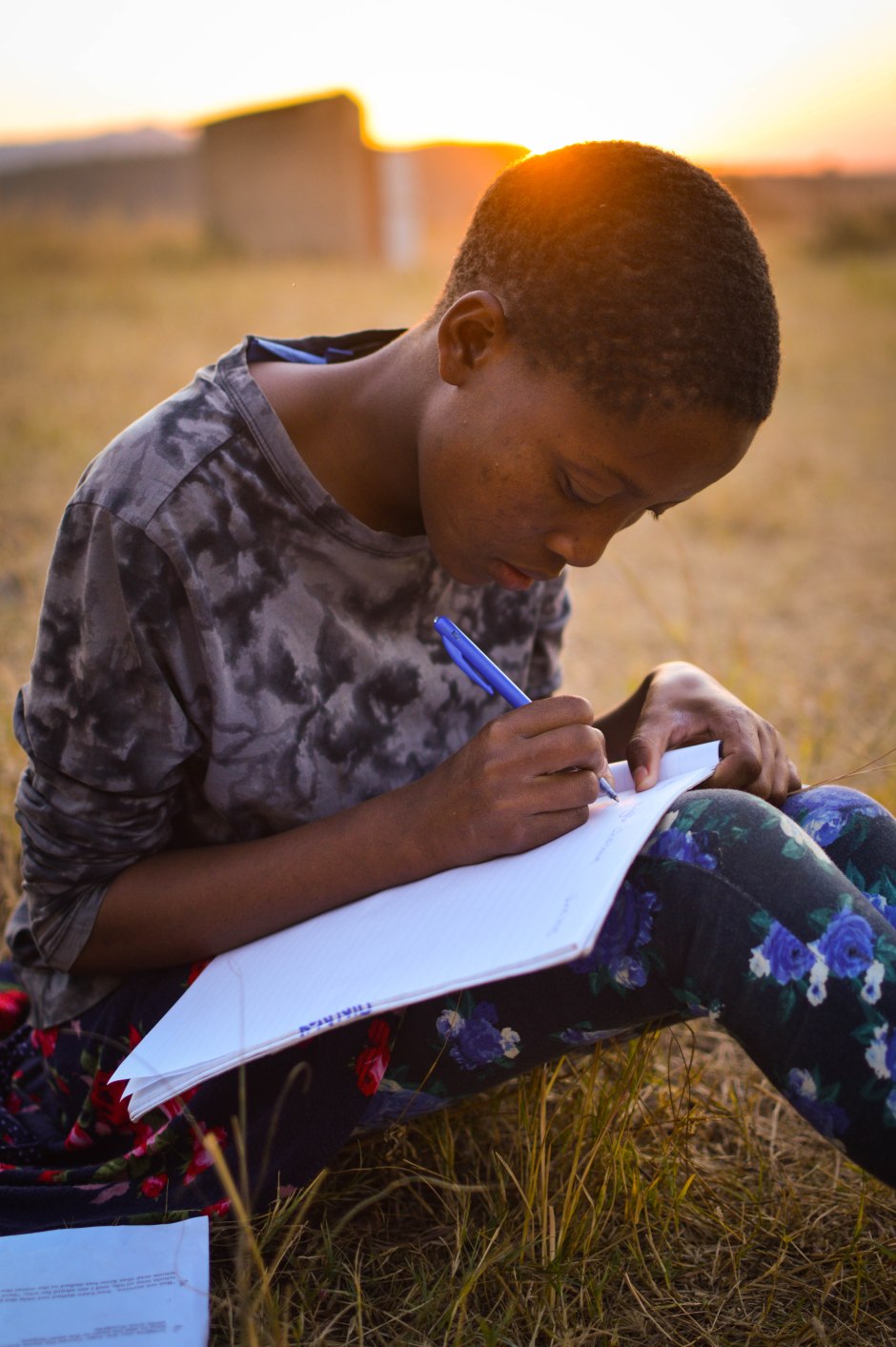 Phindiswe, age 14, does her English homework as the sun sets. Swaziland, June 2015.