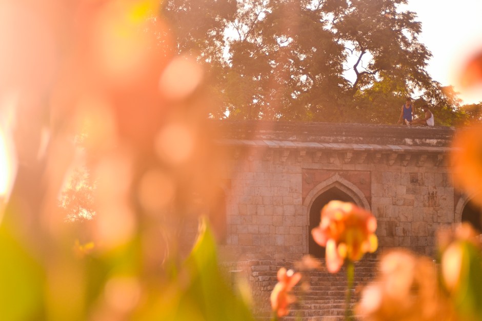 ​Two boys watch the sunrise from a rooftop structure in Lodhi Gardens in New Delhi, India. 